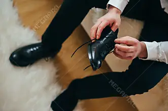 elegáns fekete cipős férfi cipőfűzőt köt